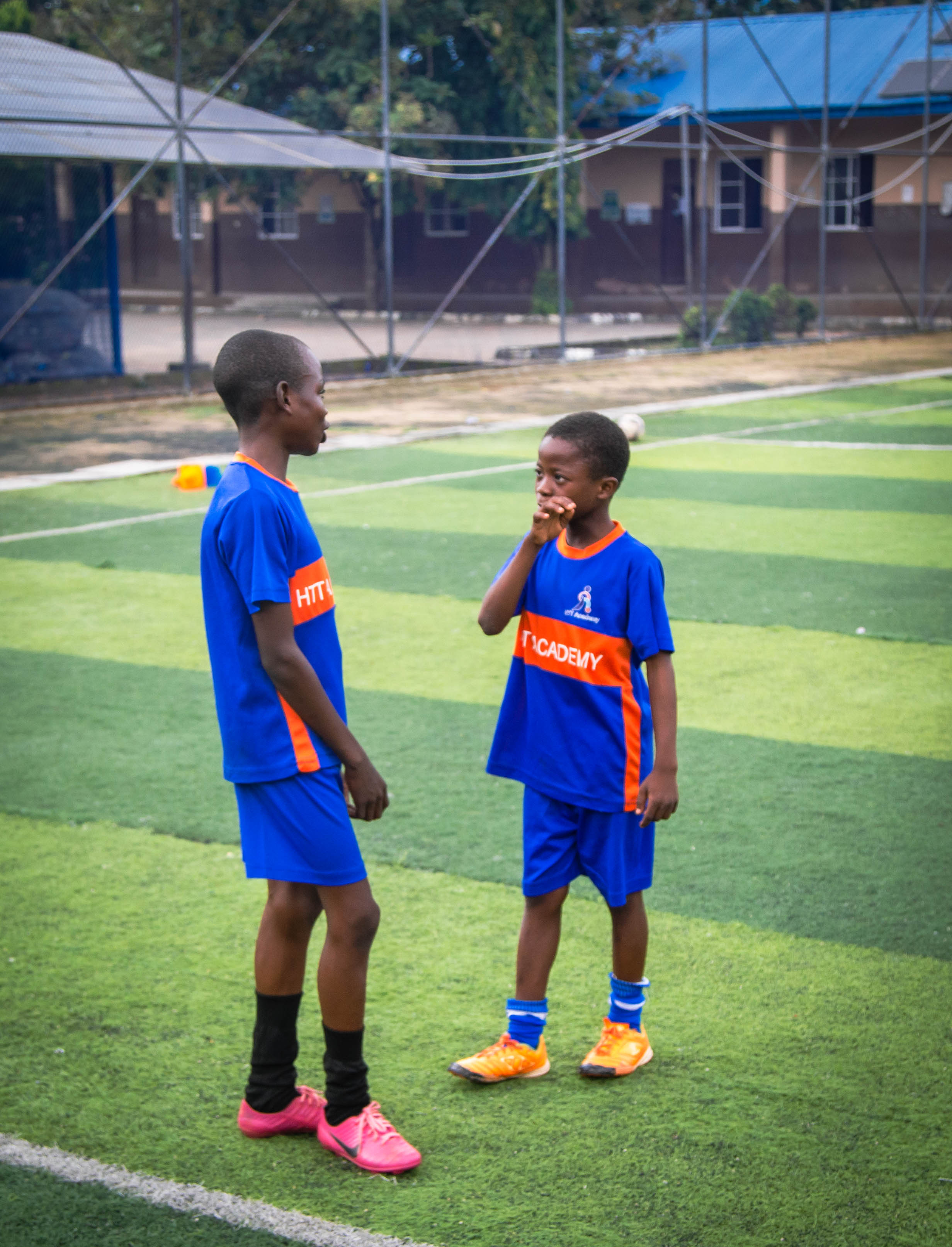 Two HTT Academy players chatting on the pitch