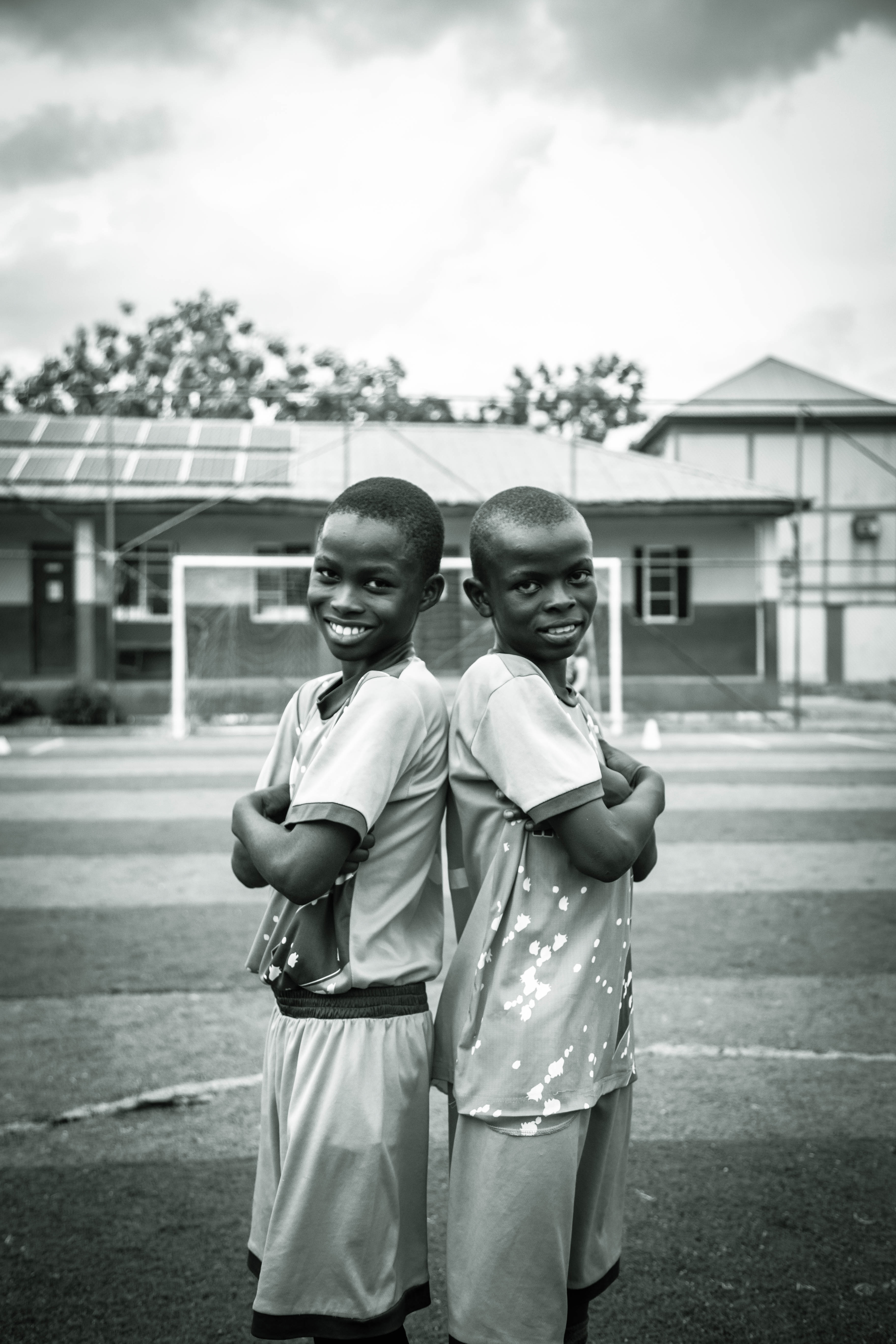 Two young players posing back to back on the field